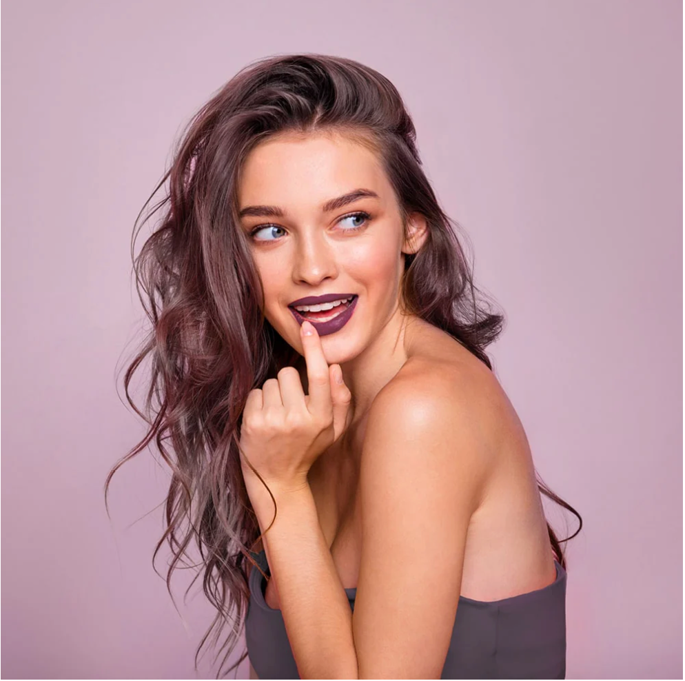 Plug anale per chi ha la clitoride per donne a forma di tulipano fun factory made in germany doppia penetrazione donna sfondo viola con aria ammiccante